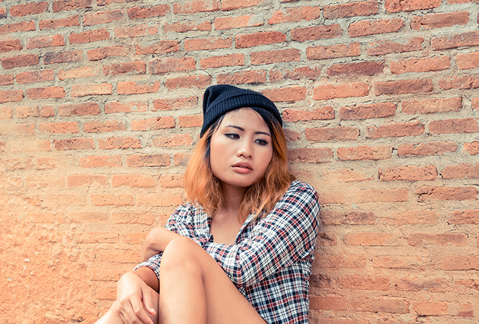 Women with Schizophrenia sitting against a wall