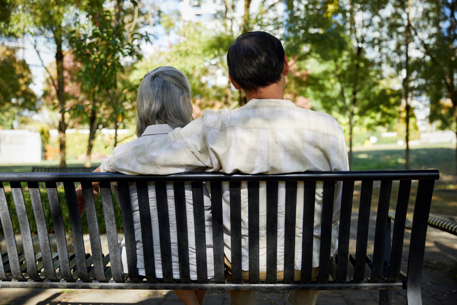 Two people on a bench, one with arm around the other